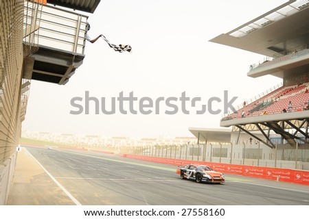 DUBAI, UAE - FEBRUARY 27: Speedcar Series driver Jean Alesi receiving the checked flag in first place at the round 4 of the Speedcar Series, in Dubai on Feb. 27, 2009.