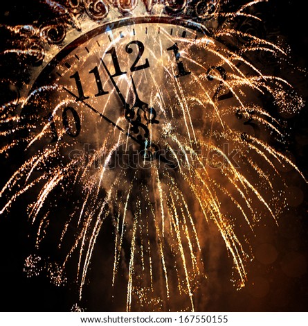 New Year's at midnight - old clock and fireworks