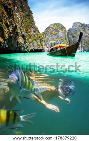 Underwater picture with fish and woman snorkeling  in Maya bay, Ko Phi Phi Le, Thailand