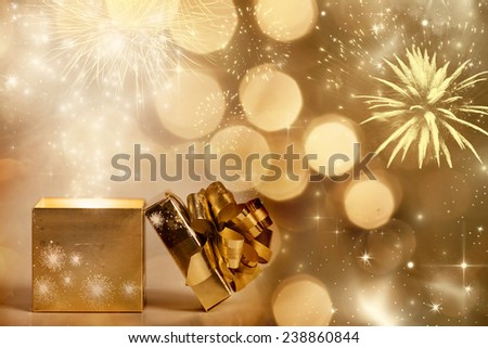 Christmas background with gift box over sparkling background and fireworks