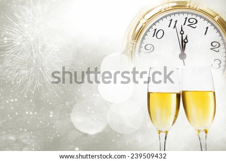 Glasses with champagne against fireworks and vintage clock close to midnight