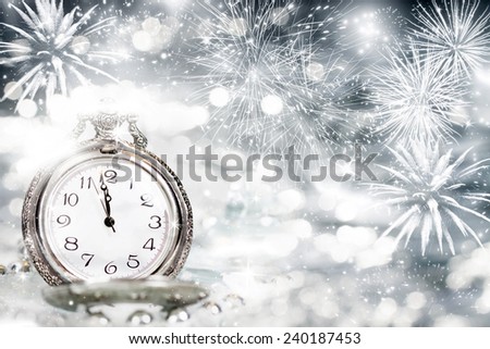 New Year's at midnight - Old clock with fireworks and holiday lights