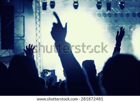 Cheering crowd in front of bright colorful stage lights - retro styled photo