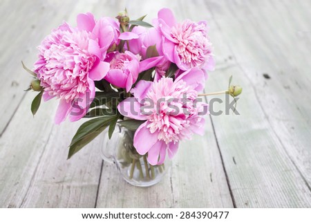 Pink peonies on wooden background
