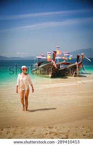 Woman walking on Tropical beach, longtail boats, Andaman Sea, Thailand