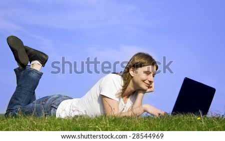 Young casual woman working on laptop outdoor