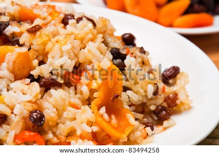 Pilaf made of rice, fresh carrots and dried plums, grapes, apricots.