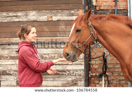 Beautiful women give an apple to her horse