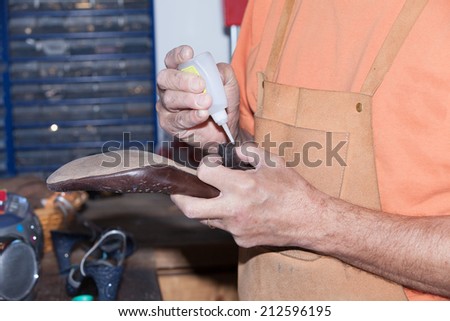 the shoemaker repairs a woman shoe