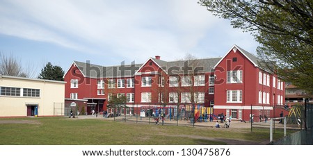School - historic red America's brick school with playground and students