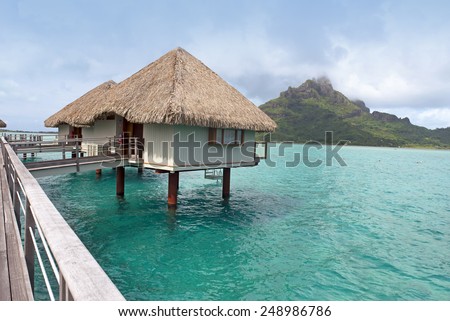 BORA BORA - JANUARY 24, 2015: World famous holiday destination Bora Bora and Tahiti  are a part of French Polynesia. Over-water bungalows are posed in blue-green waters of South Pacific Ocean.