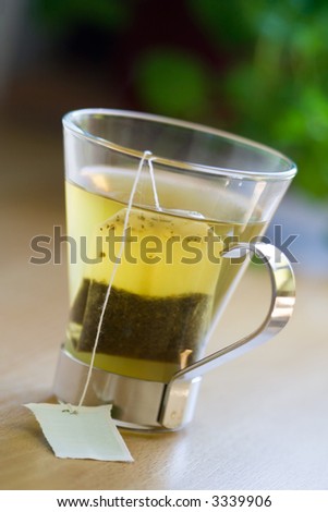 Green tea bag in glass tea cup