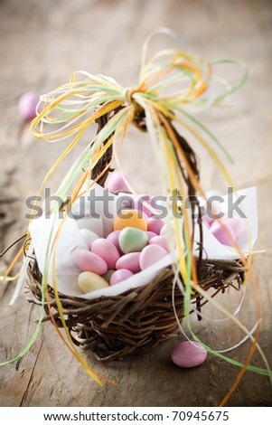 Colorful easter candy in brown basket with ribbon