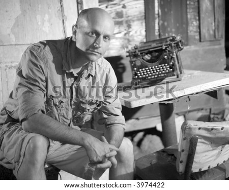 Man sitting next to a vintage typewriter