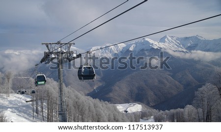 Gondola lift against panoramic view of mountain range