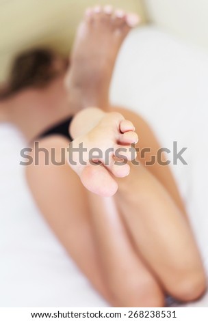 Clear feet of a woman lying in bed close up. Health care