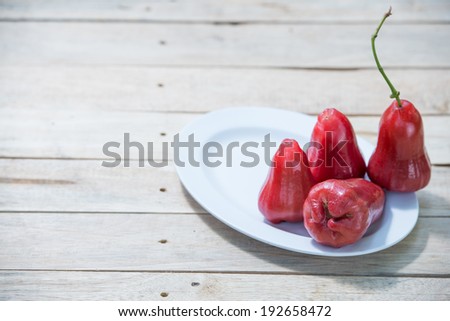 Four Rose apples on wooden table