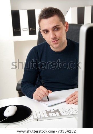 Young man thinking in front of his computer in the office ambient