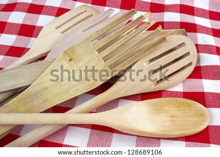 Wooden cooking spatulas closeup on checked fabric