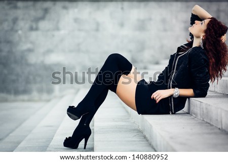 Beauty girl sits on a concrete steps