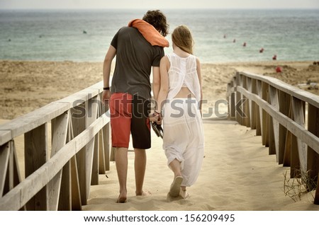 Lovers\' young couple walking along the beach