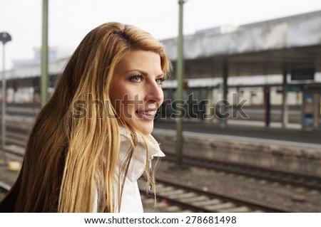 young woman waiting on platform at the train station