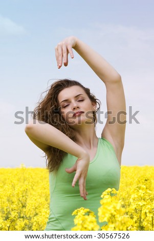 Portrait of a young woman doing yoga in rapeseed field