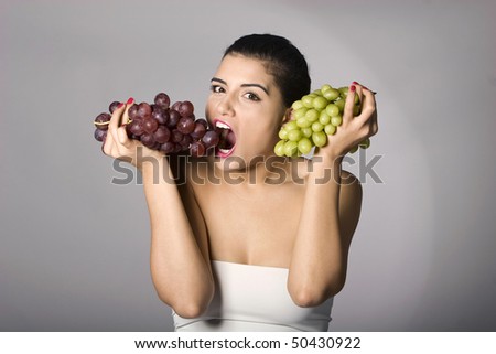 Part of photo series. Woman with mix of grapes. Studio shot