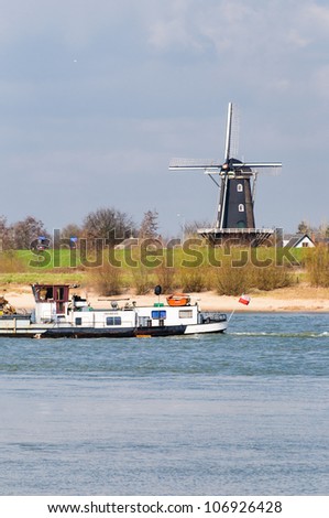 Looking out over a river in Holland to a windmill, just when a (Polish) ship passes by