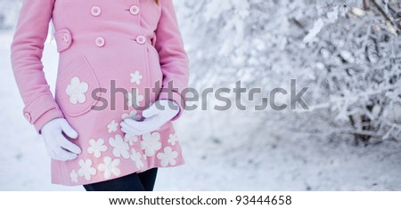 Young happy pregnant woman in snowy forest