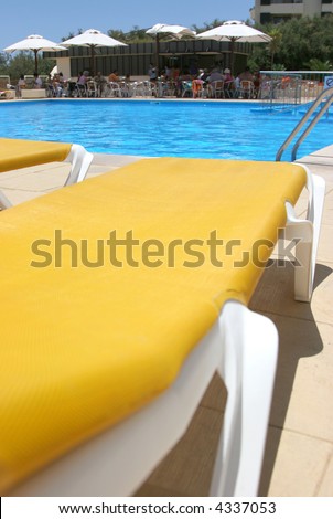 pool restbeds closeup with pool water and bar as background