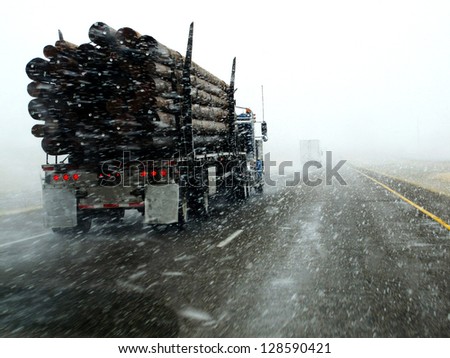 Semi truck driving down highway during blizzard snow storm