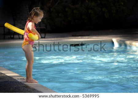 Young girl preparing to jump into a swimming pool
