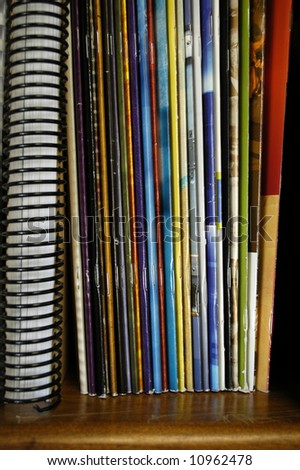 Closeup of a stack of many colorful magazines on a shelf