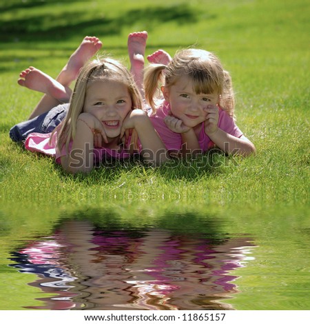 Two sisters in pink shirts resting their heads on their hands at the park
