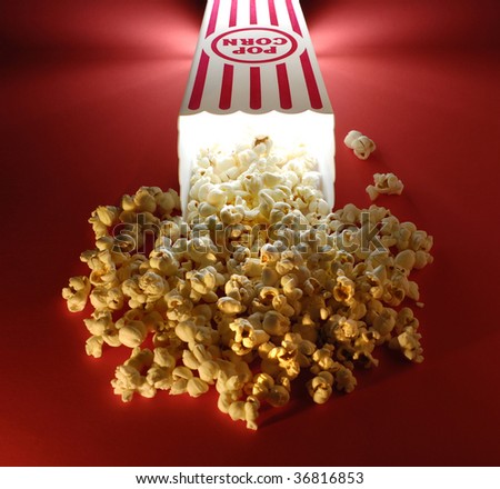 Popcorn for a movie in a popcorn holder and spilling out