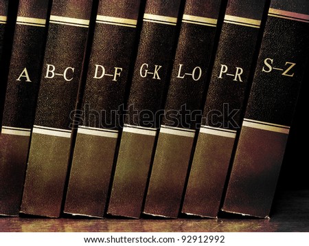 Row of old leather books on a shelf with alphabet
