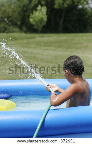 Boy Squirting Water Hose In A Pool Stock Photo 372651 : Shutterstock