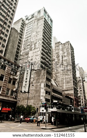 HONG KONG, CHINA - JULY 30, 2012: Street,  trams and buildings on July 30, 2012 in Hong Kong, China. With 7M population and land mass of 1104 sq km, it is one of the most dense areas in the world