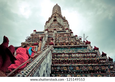 BANGKOK, THAILAND - AUGUST 3: Buddhist monks walk up stairs of Wat Arun temple, in Bangkok on August 3, 2012. Buddhism is Thailand official religion and is the religion of more than 90% of its people