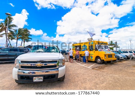 WAIKIKI, HAWAII - SEPTEMBER 7, 2013: Gilligan\'s Beach Shack food truck with customers and Police car in Waikiki, Hawaii. The vendor is a mainstay of Waikiki and made famous for TV show Hawaii 5-O