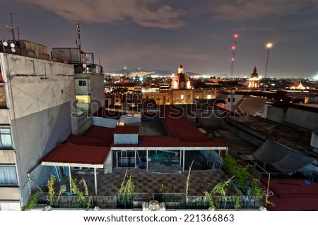 MEXICO CITY, MEXICO - APRIL 29, 2014: night view of skyline with brightly lit suburban barrios in the background in Mexico City, Mexico. The city is located at an altitude of 2,240 metres.