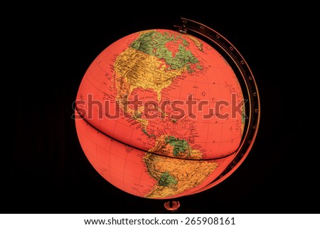 MILAN, ITALY - DECEMBER 17, 2014: vintage red light world globe illuminated from within with black background in Milan, Italy.