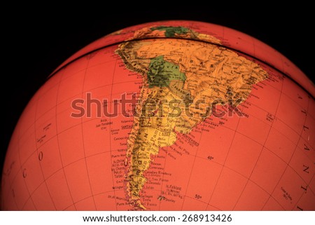 MILAN, ITALY - DECEMBER 17, 2014: red light world globe illuminated from within with closeup on South America. A globe is the only representation of the earth that does not distort its shape or size.