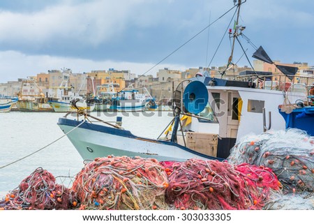 TRAPANI, ITALY - FEBRUARY 25, 2014: day view of harbor, boat with fishing nets and waterfront in Trapani, Italy. The city is an important fishing port and the main gateway to the nearby Egadi Islands