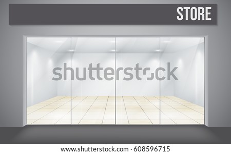 A view from the outside to the empty interior of the store through a large glass case.