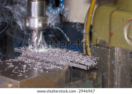 Milling machine is cutting metal with lot of smoke