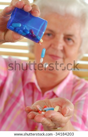 Image of senior lady pouring pills from container to hand
