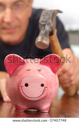 A man with a hammer is about to break a piggy bank to get money