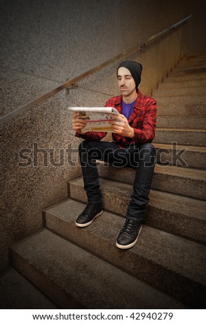 A man sitting on stairs and reading a newspaper